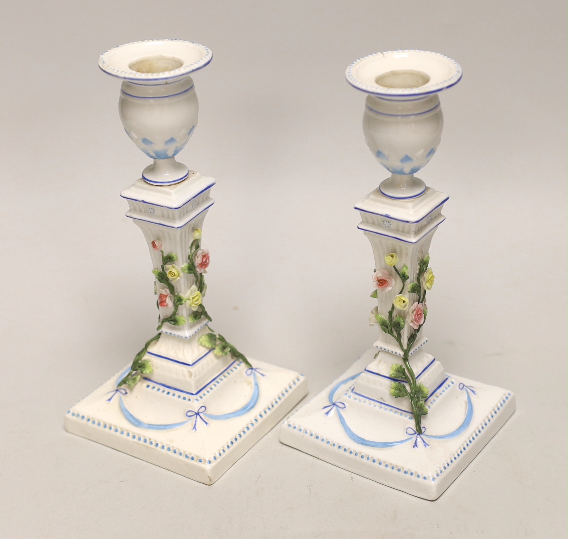 A pair of German porcelain candlesticks, marked JR, with applied floral decoration, 18cm